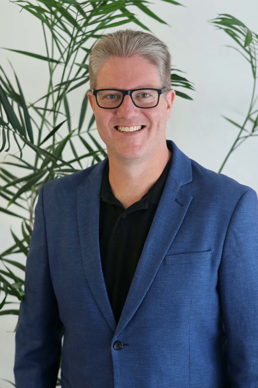 Moss McEwen, mortgage and finance broker at Bay Finance Co, smiling in a blue blazer